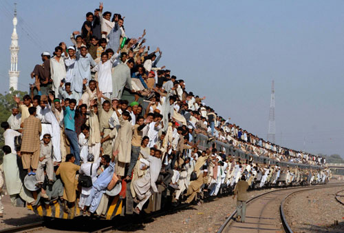 A Train with people all over it Crowd on an Indian Train